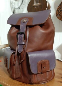Handcrafted rucksack made from Montana vegetable tanned cowhide with purple chrome tan goatskin accents.